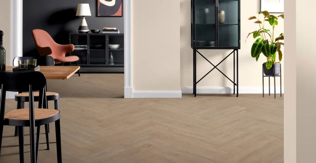 Hier ist ein Ambiente Bild eines hellen Laminatbodens ins Fischgrätoptik zu sehen