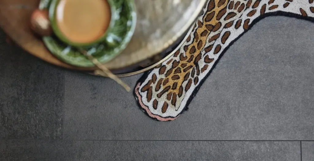 Ein Ambiente Bild auf dem ein dunkler anthrazit farbiger Laminatboden in Fliesenoptik zu sehen ist.  