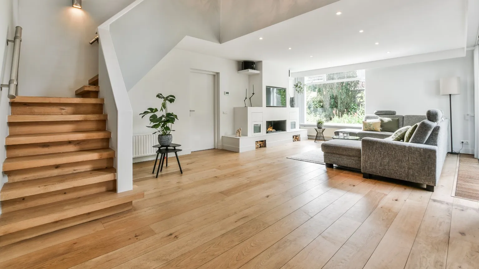 Offenes Wohnzimmer mit Treppe nach oben und Parkett