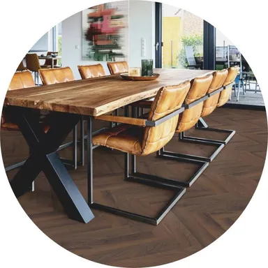 Hier ist ein Ambiente Bild eines dunklen Laminatbodens ins Fischgrätoptik zu sehen