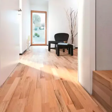 Raum mit lebhaftem Parkett und schwarzem Couchtisch und Sessel