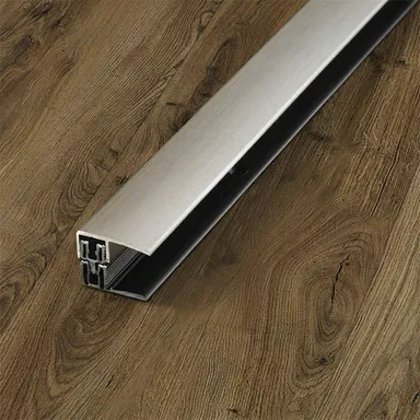 Ein  Abschlussprofil auf Edelstahl das auf einem dunklen Boden zu sehen ist.