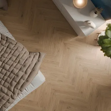 Hier ist ein heller Parkettboden Eiche in Fischgrätoptik zu sehen.