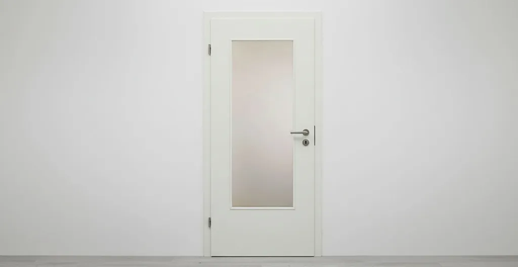 Hier ist eine weiße Wand mit einer eingebauten weißen Zarge und einer Tür.