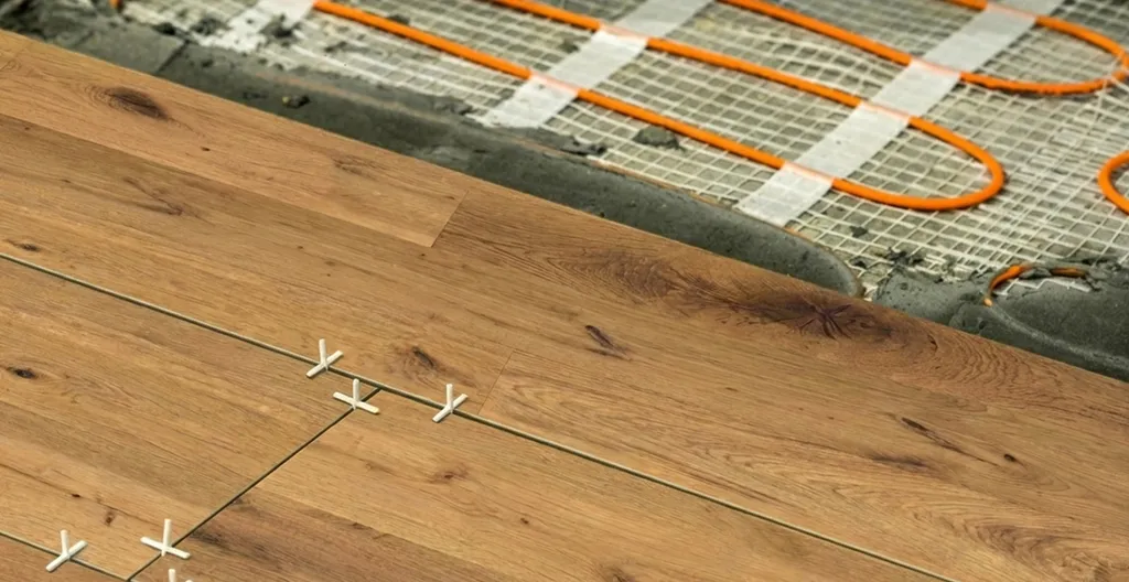 Hier ist ein dunkler Echtholzparkettboden zu sehen, welcher auf einer Fußbodenheizung verlegt wird.