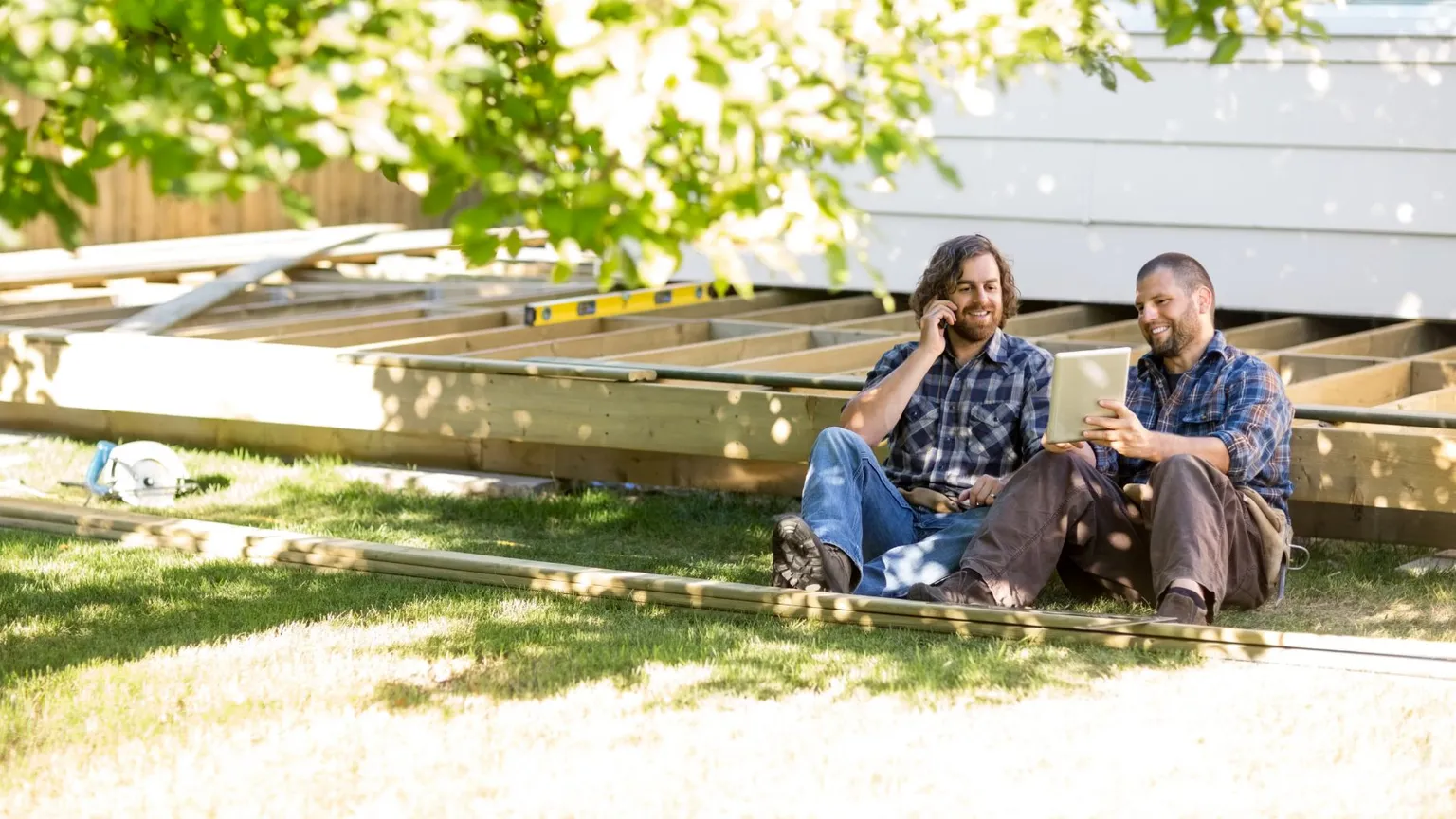 Terrassenplaner - zwei Männer sitzen vor Terrasse mit Tablet 