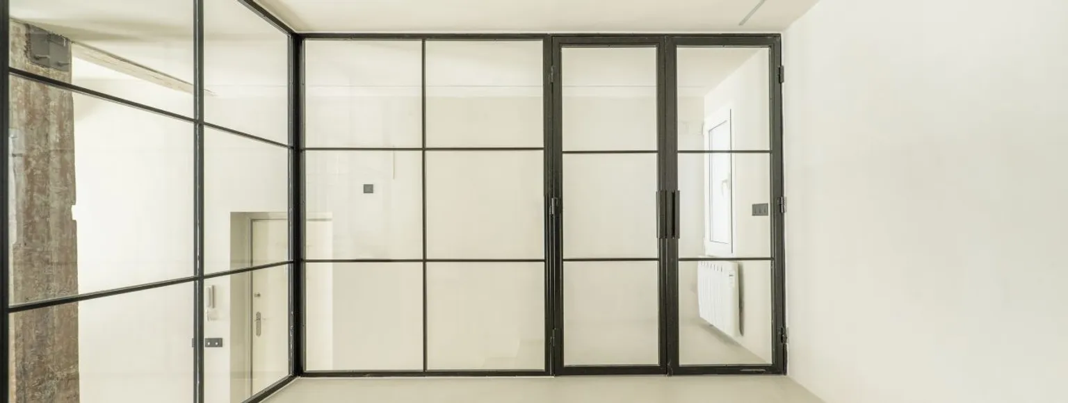 Glasfront mit Loft-Tür und schwarzen Streben 