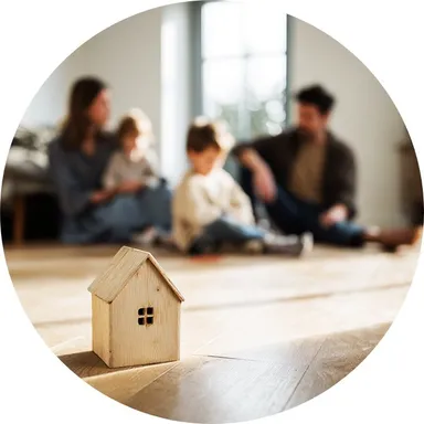 Hier ist ein Ambiente Bild eines hellen Laminatbodens mit Trittschalldämmung zu sehen. Im Hintergrund sitzt eine Familie auf dem Boden.