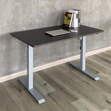 Höhenverstellbarer Schreibtisch mit einer dunklen Platte und silbernen Füßen